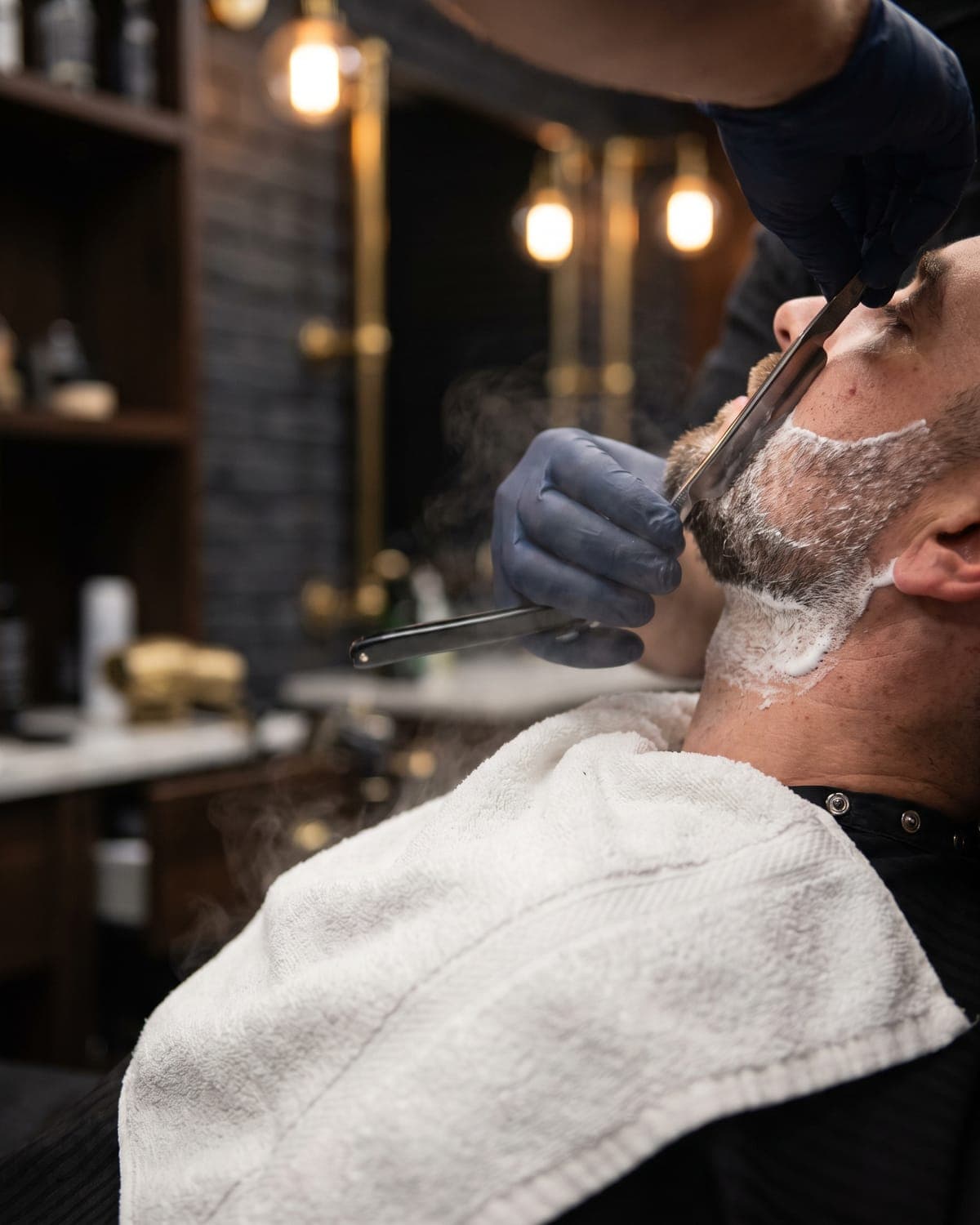 A straight razor shaping a lathered beard line